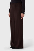 Brown wide-leg pants worn by a person on a white background