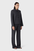 Woman wearing a dark gray suit on a white background